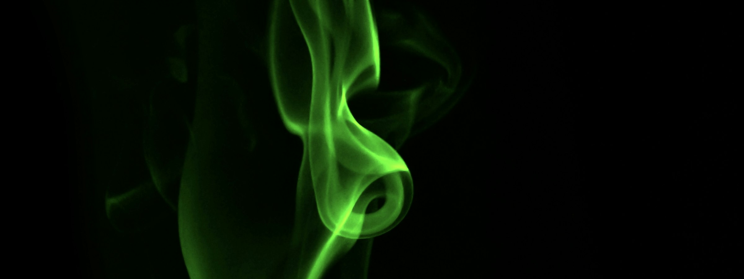 Volute de fumée verte sur fond noir